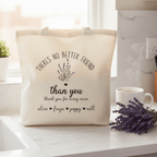 Cream tote bag on tabletop with “There’s No Better Friend” and custom “than you” names