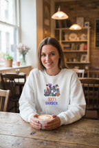 White crewneck sweatshirt with floral graphic and 'ALICE'S GARDEN' print