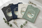 Set of four T-shirts with “Our Happy Place” scenic landscape wreath prints