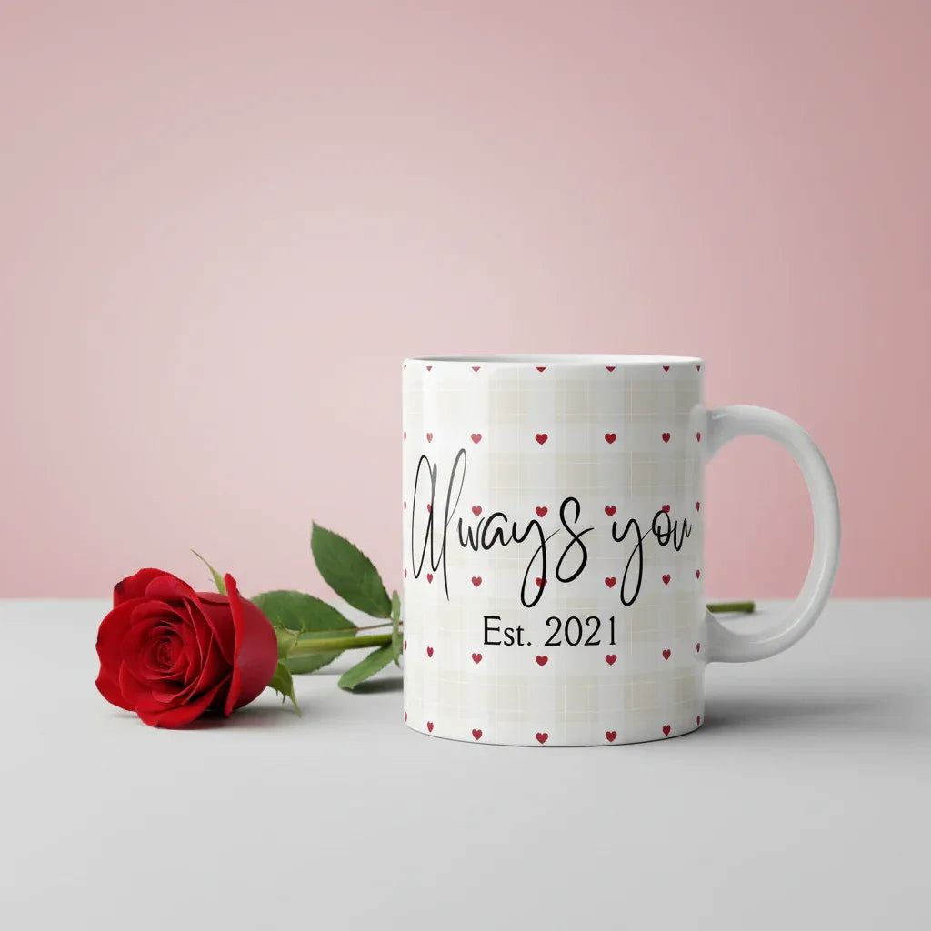 White anniversary mug with red heart pattern, black cursive text and “Est. 2021”.