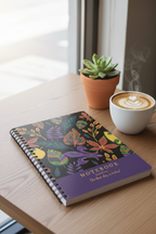 A5 leaf notebook on wooden table with spiral binding, colorful cover, and drink cup