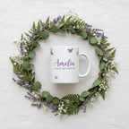 Personalised butterfly mug with purple butterfly icons and Amelia date text, white ceramic