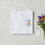 Personalised white T-shirt with “CHUFFED TO BITS” bird graphic and name “Amelia”.