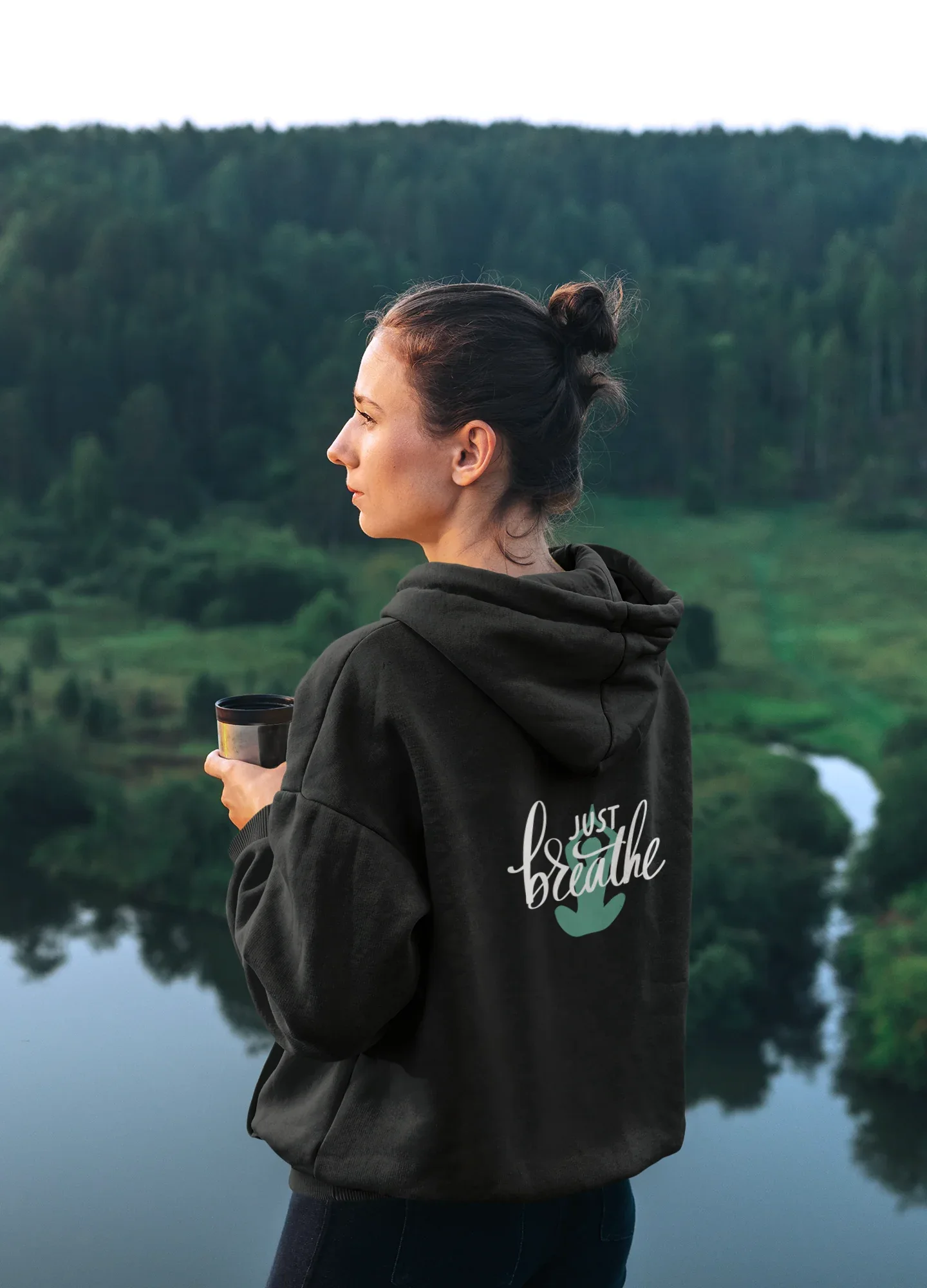 Black hoodie with kangaroo pocket and 'Just Breathe' logo on back, side view