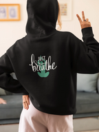 Black hoodie with drawstring hood and 'Just Breathe' logo on back