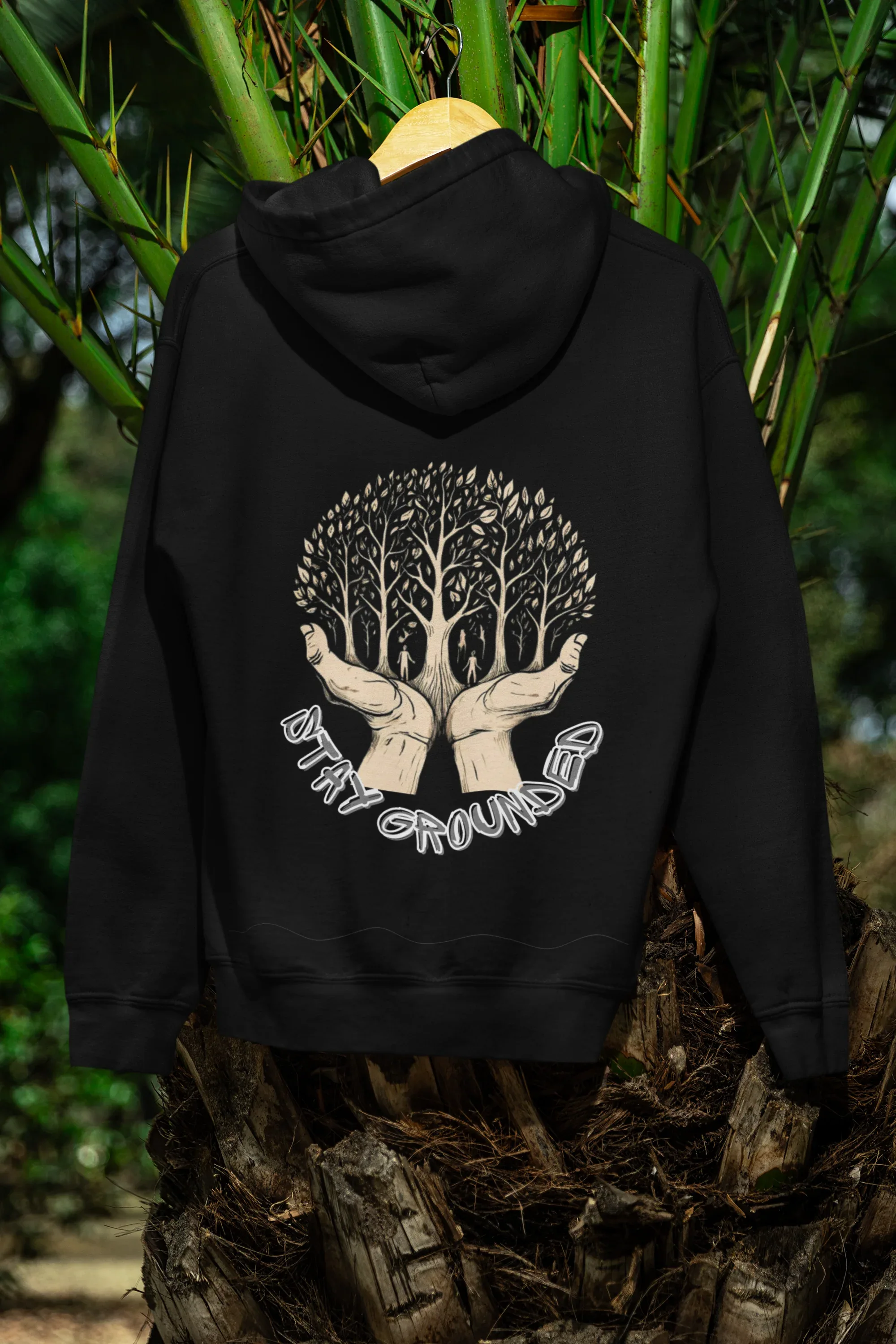 Black hoodie outdoors with back tree graphic and arched text