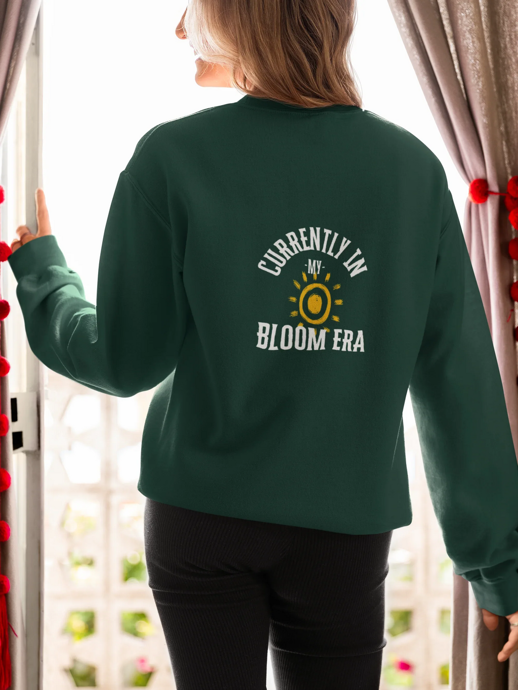 Forest green sweatshirt with crew neck and sun-and-flower "Bloom Era" back print