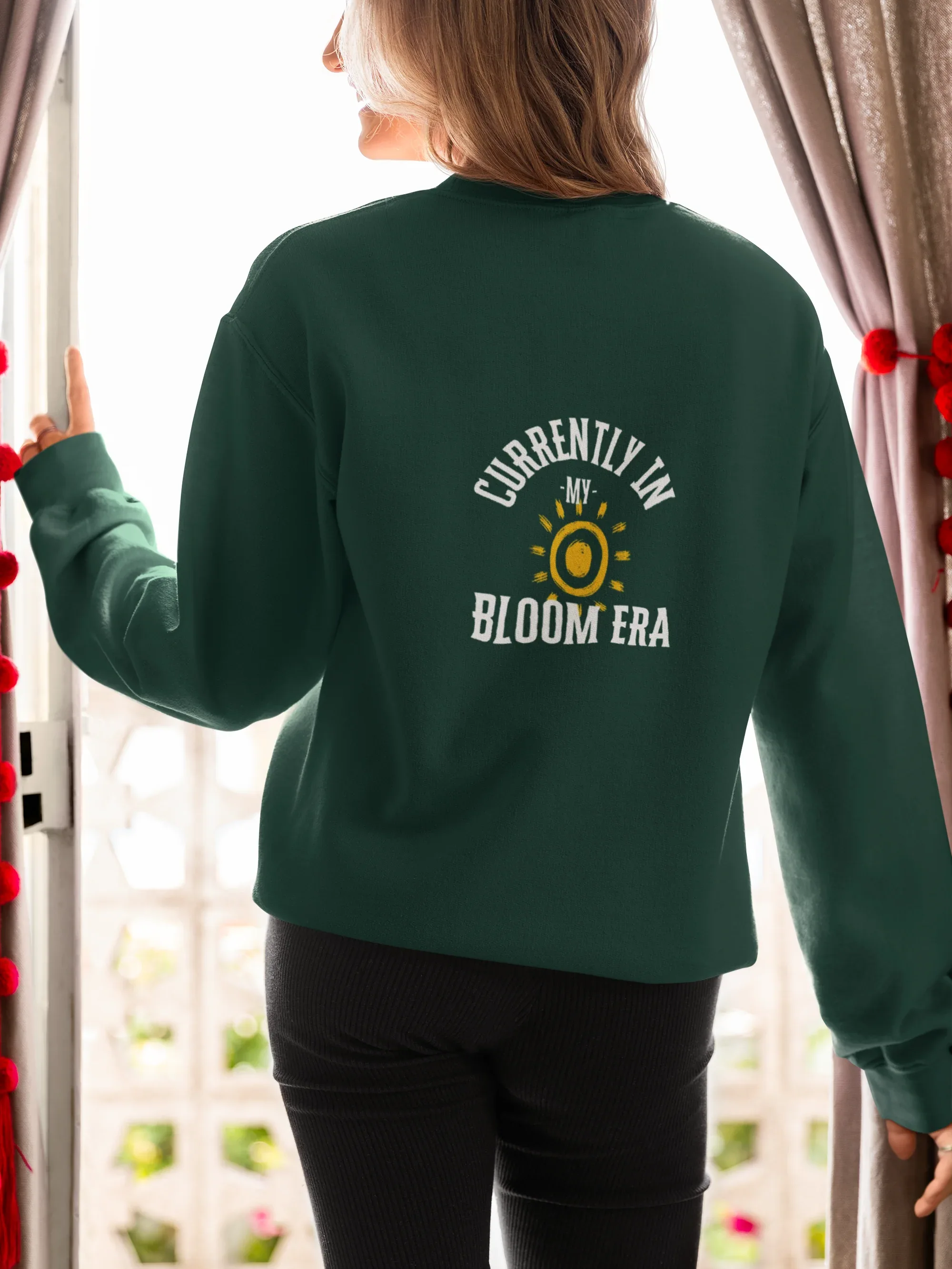 Forest green sweatshirt with crew neck and sun-and-flower "Bloom Era" back print