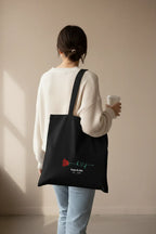 Black personalized tote bag back view with red rose print and 'Katie&Jake' text