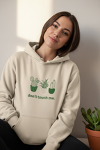 Sand hoodie with green cactus graphic and "don't touch me." text on the chest