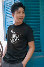 Black unisex heavy cotton T-shirt with coffee cup graphic and gold script on chest