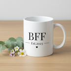 White ceramic mug with handle, front shows BFF Est.2023 and heart