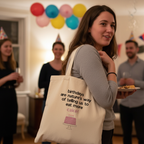 Cream tote bag with quote and pink cake graphic on front, carried by a person