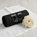 Black graduation tote bag with ribbon and text, folded with a white flower