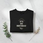 Black hooded sweatshirt, flat-lay view, with 'It's My Birthday' chest graphic