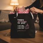 Black cotton tote bag with pink ribbon handles and 'happy birthday to you' print.