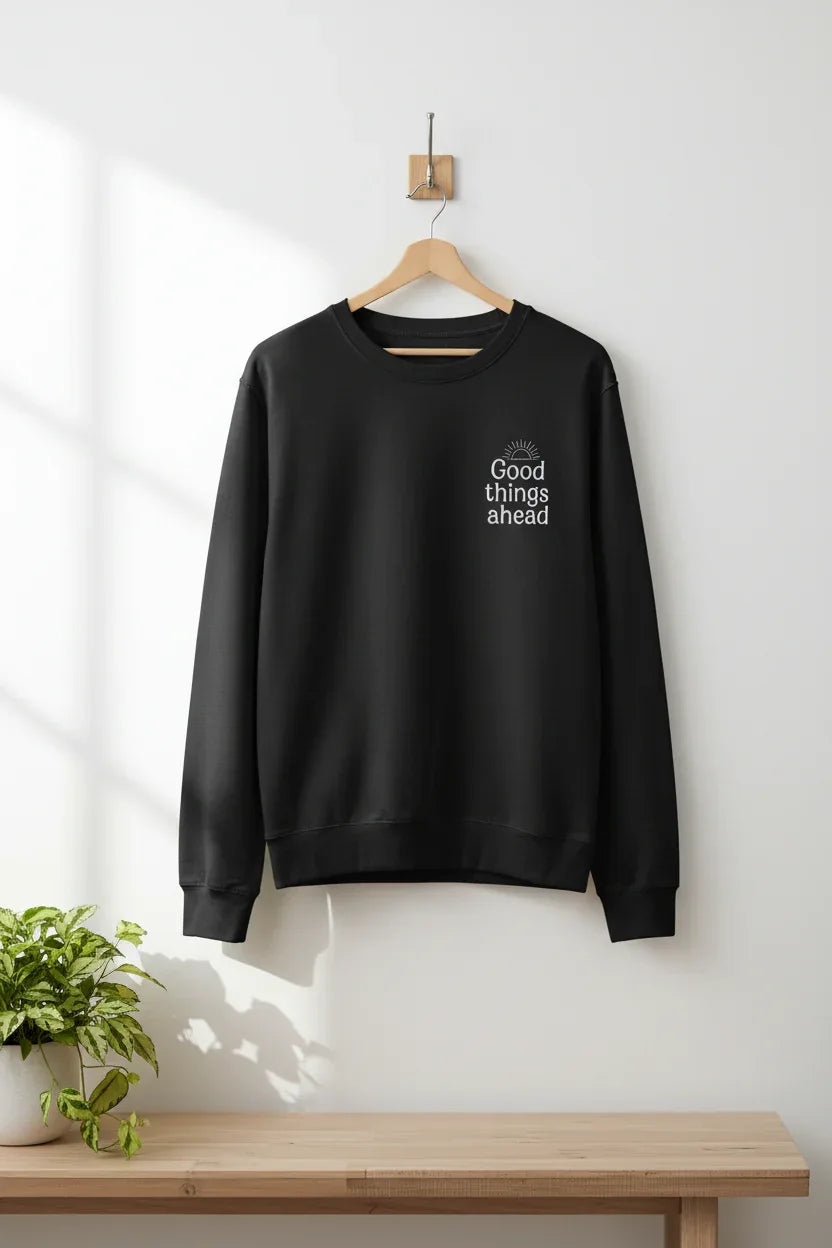 Black crewneck sweatshirt hanging on a wooden hanger with chest logo