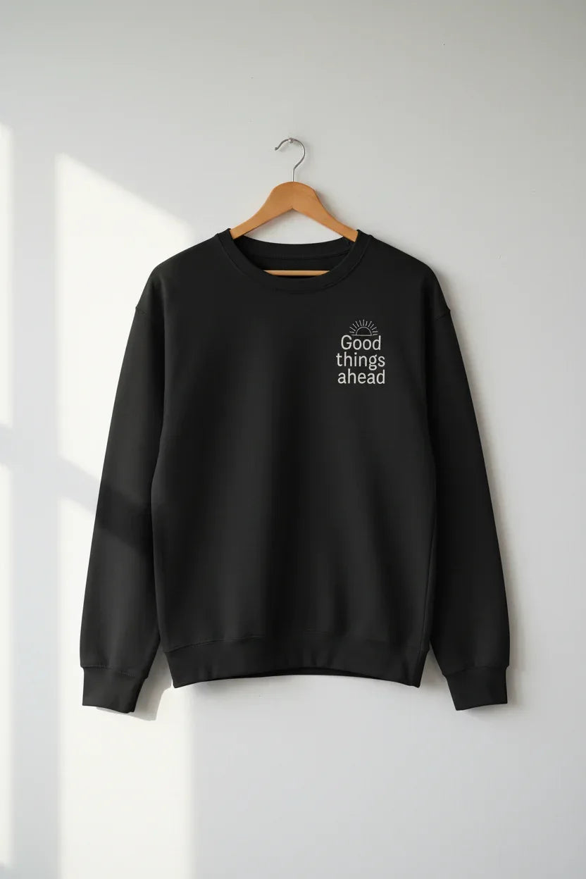 Black crewneck sweatshirt with small chest logo, hanging on a wooden hanger