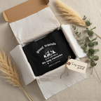 Black tote in open kraft gift box flat lay