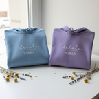 Set of blue and purple hoodies with drawstring hoods and “delulu vibes” print