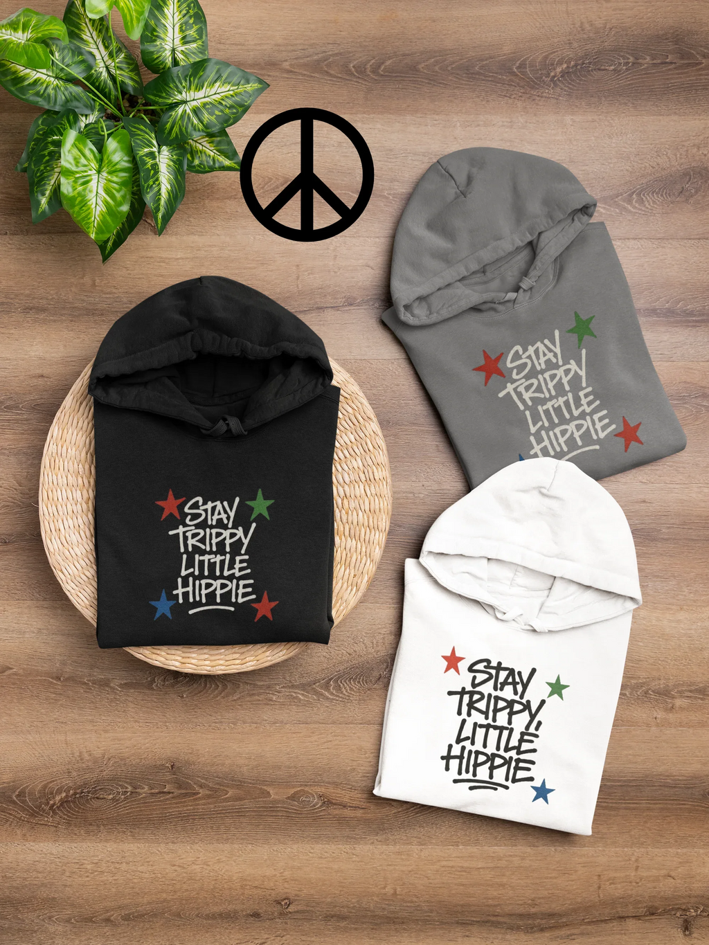 Folded hoodies set: black, gray, and white with colorful "Stay Trippy Little Hippie" print