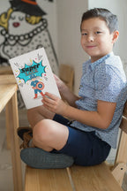 Superhero journal with colorful comic cover, held by a child