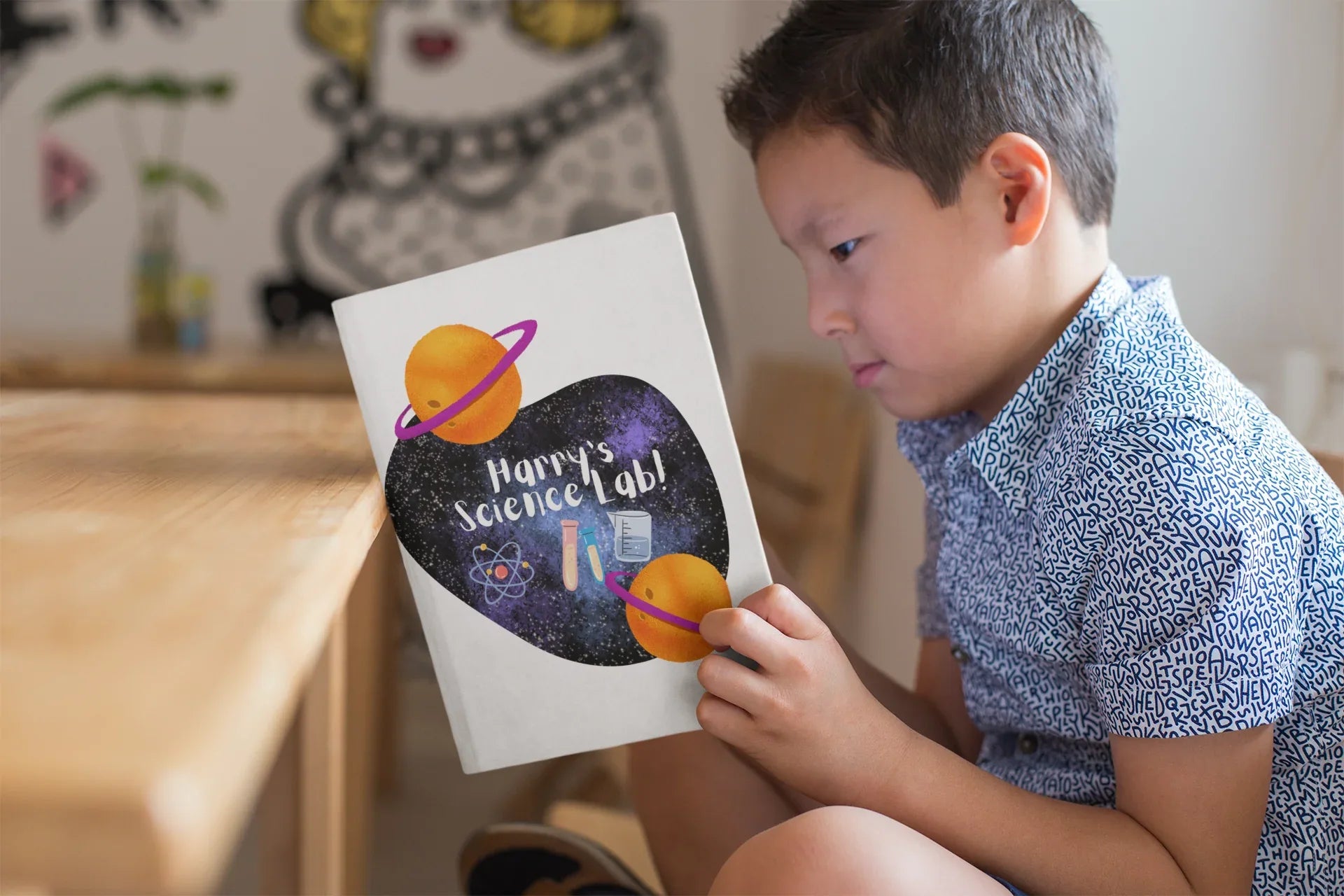 Science-themed journal held by a child with heart space cover design
