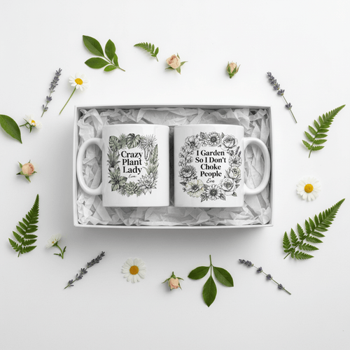 Gift box with two white ceramic mugs, each showing floral quote designs and handles.
