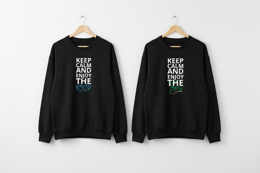 Two black crewneck sweatshirts with front slogan graphic hanging on hooks