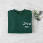 Bottle green crewneck birthday shirt with “This is my BIRTHDAY shirt” print.