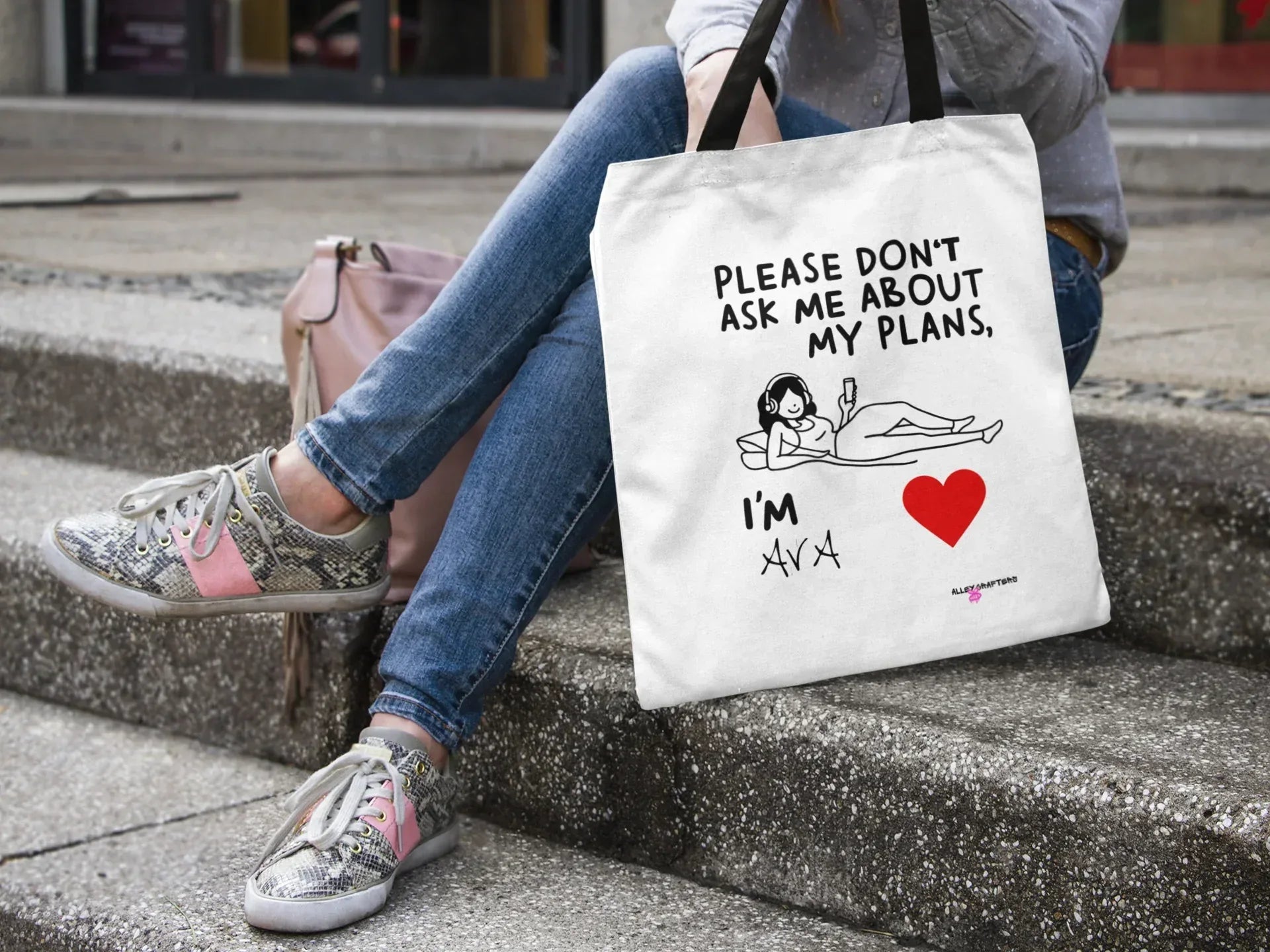White canvas tote bag on steps with black straps, “Please don’t ask me about my plans” quote