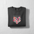 Dark gray crewneck sweatshirt with “Birthday Girl” text and pink floral heart graphic