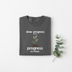 Charcoal gray T-shirt with "slow progress" slogan and minimal plant graphic, crew neck.