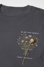 Personalised charcoal t-shirt with botanical branch graphic and "In my own season" text, Sophie/Manchester