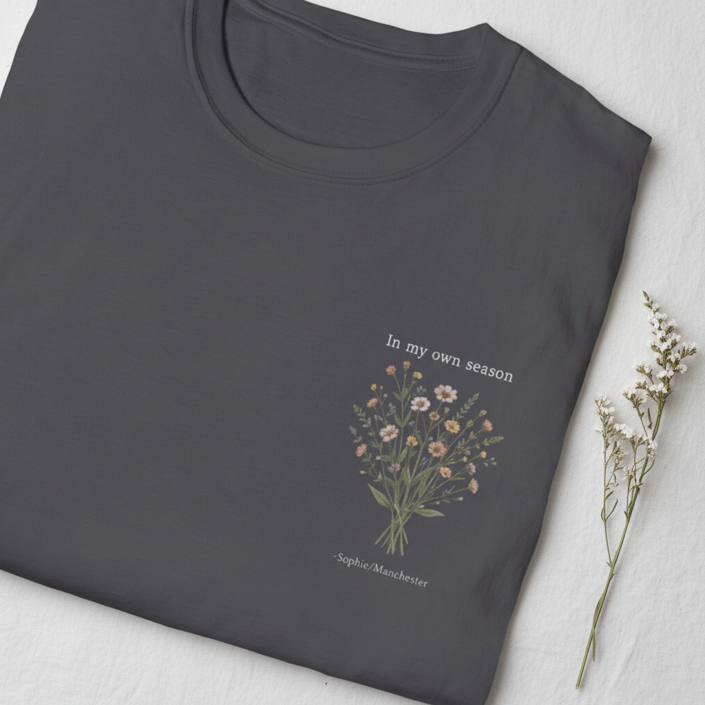 Dark gray T-shirt with small botanical bouquet graphic and signature text