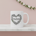 White ceramic mug with floral heart wreath and name Charlotte, printed front