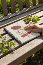 A5 floral journal notebook on wooden bench, hand resting on beige floral cover