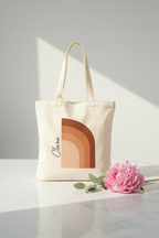 White cotton tote bag with terracotta arch print and handwritten-style text on side