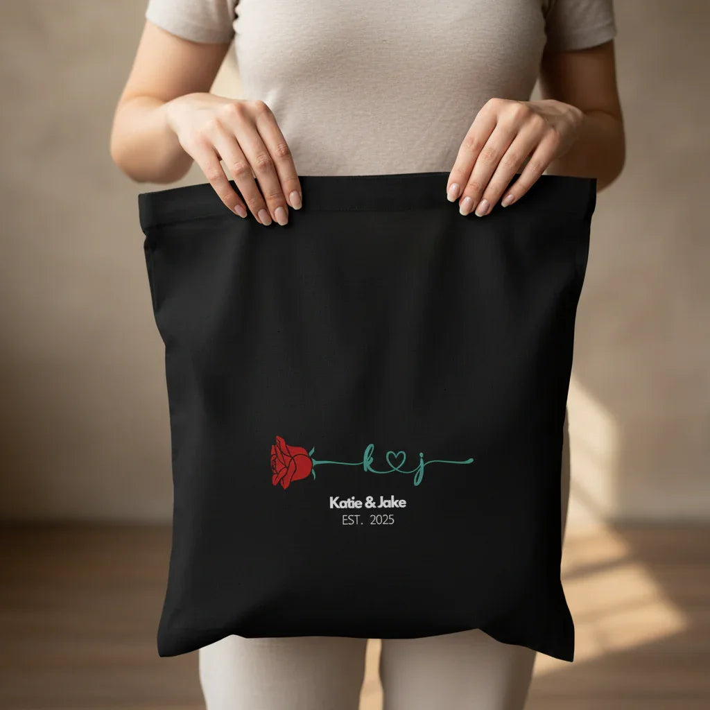 Black personalized rose tote bag close-up with red rose and 'Katie&Jake' text