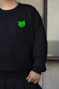 Black sweatshirt with small green frog face embroidery on the left chest
