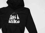 Black Take a Hike hoodie with hood; front chest graphic visible.