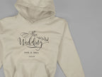 Cream wedding day hoodie sweatshirt with “The Wedding” logo print and front pocket