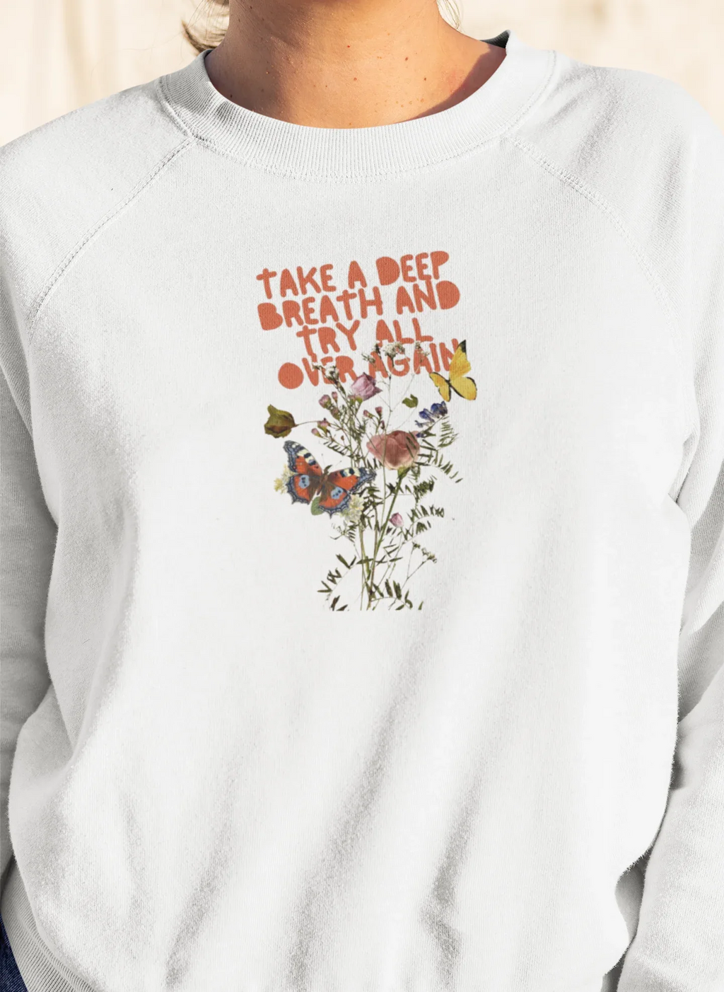 Light gray crewneck sweatshirt with floral quote graphic on chest, crew neckline