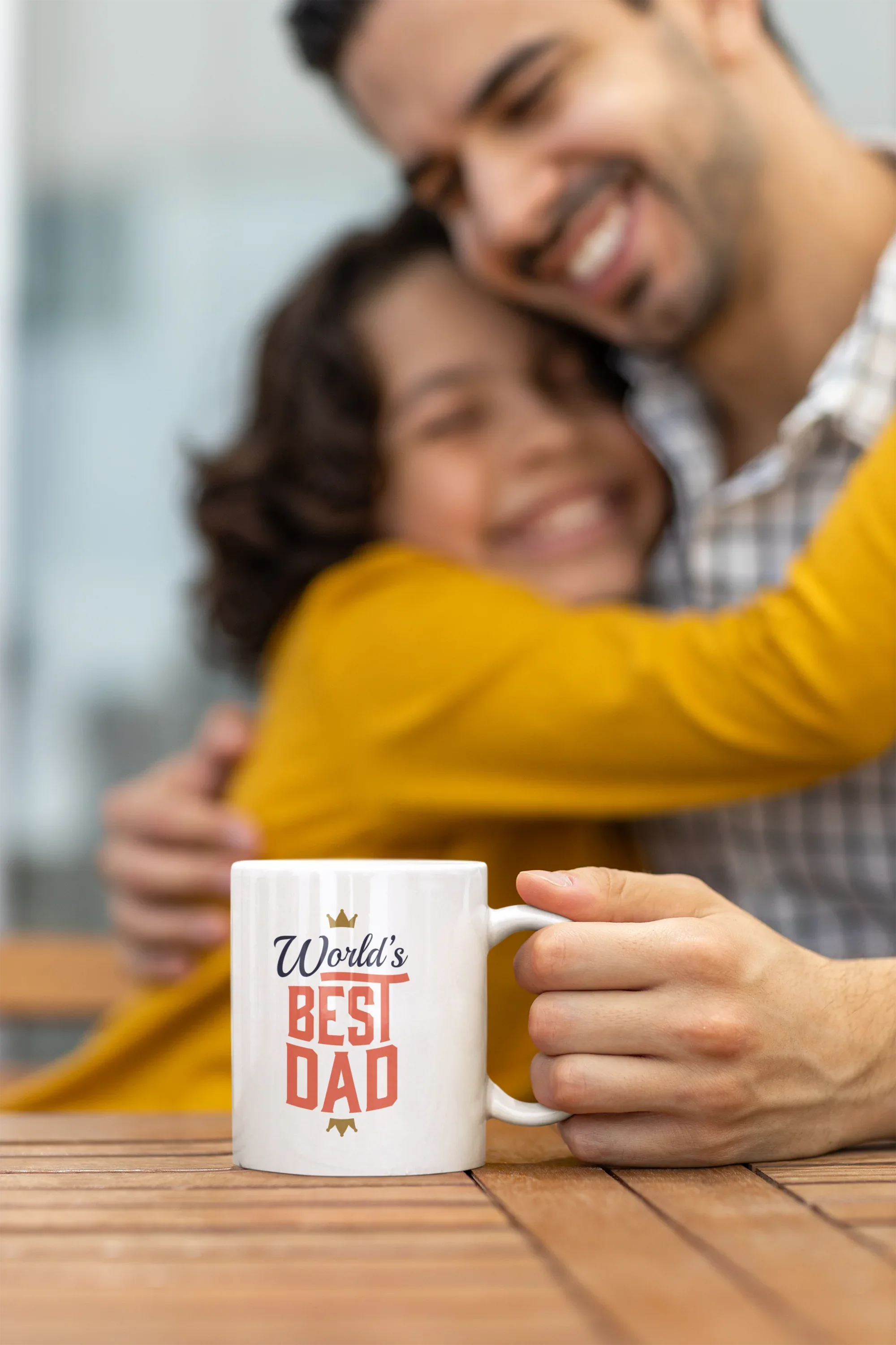 White mug with World's Best Dad crown and red stacked letters, held on tabletop.