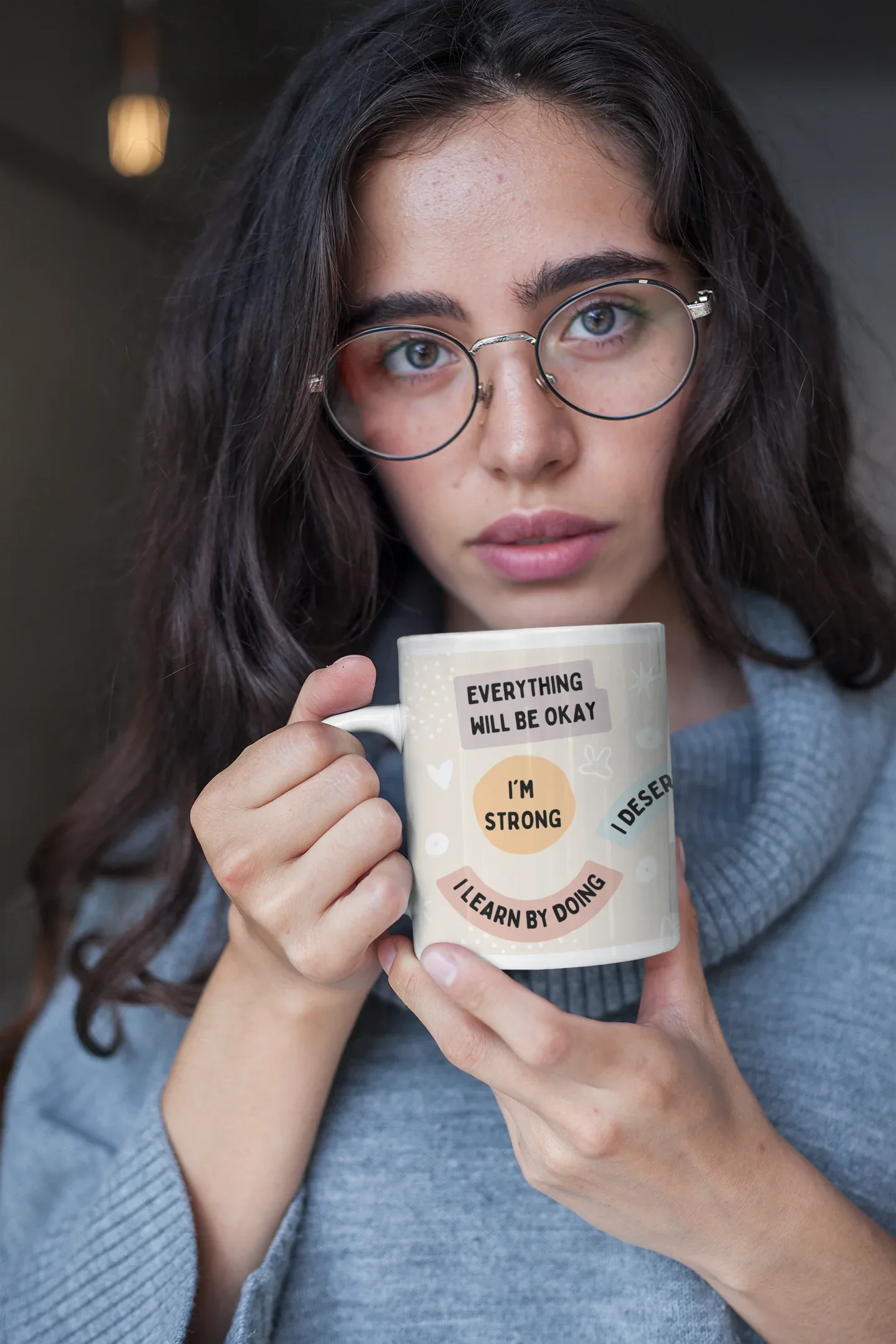 White ceramic positivity mug held up showing 'Everything will be okay' message