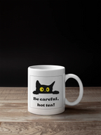 White mug with black cat and yellow eyes, 'Be careful, hot tea!' print