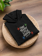 Black hoodie folded on basket with colorful "Stay Trippy Little Hippie" print