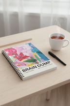 A5 spiral notebook on tabletop, colorful floral cover with black rings and lined pages