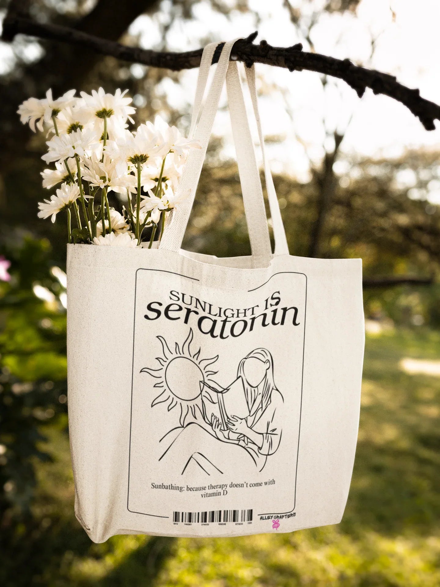 White canvas tote bag with black front design hanging from two straps