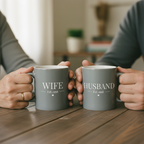 Personalized coffee mugs, matte light gray, labeled 'WIFE' and 'HUSBAND' with Est. year